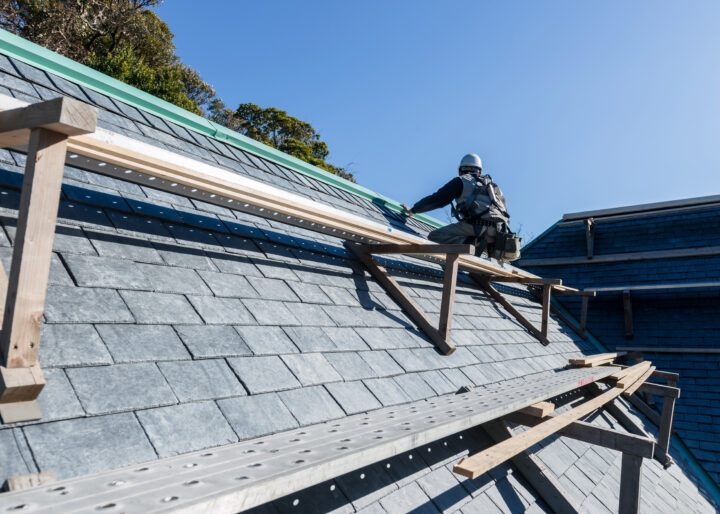 屋根を修繕する作業員